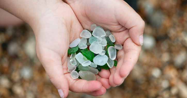 child's hands holding sea glass collected on Seaham Beach, Durham Heritage Coast